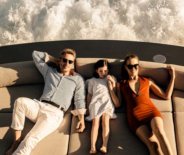 Family lounging on aft cushion of yacht