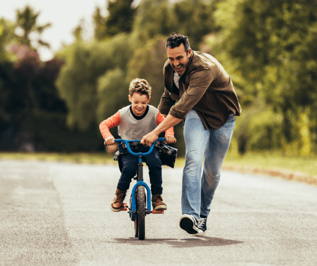 Father with son learning to ride a bicycle