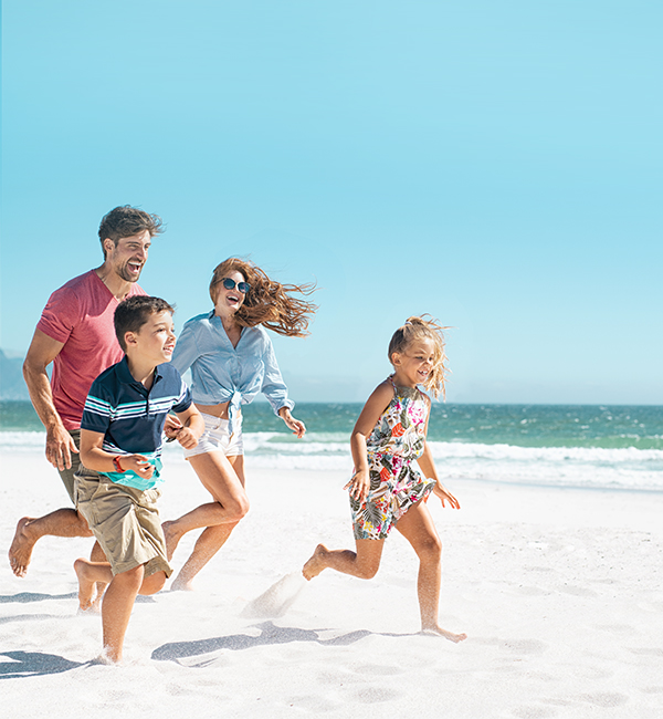 Family running on the beach together