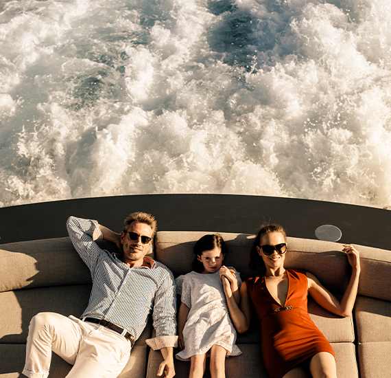 Man woman and child laying on back of boat