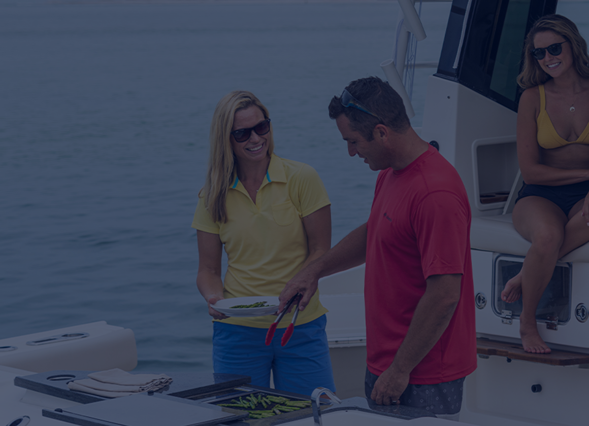 man serving woman food with other woman sitting on boat behind